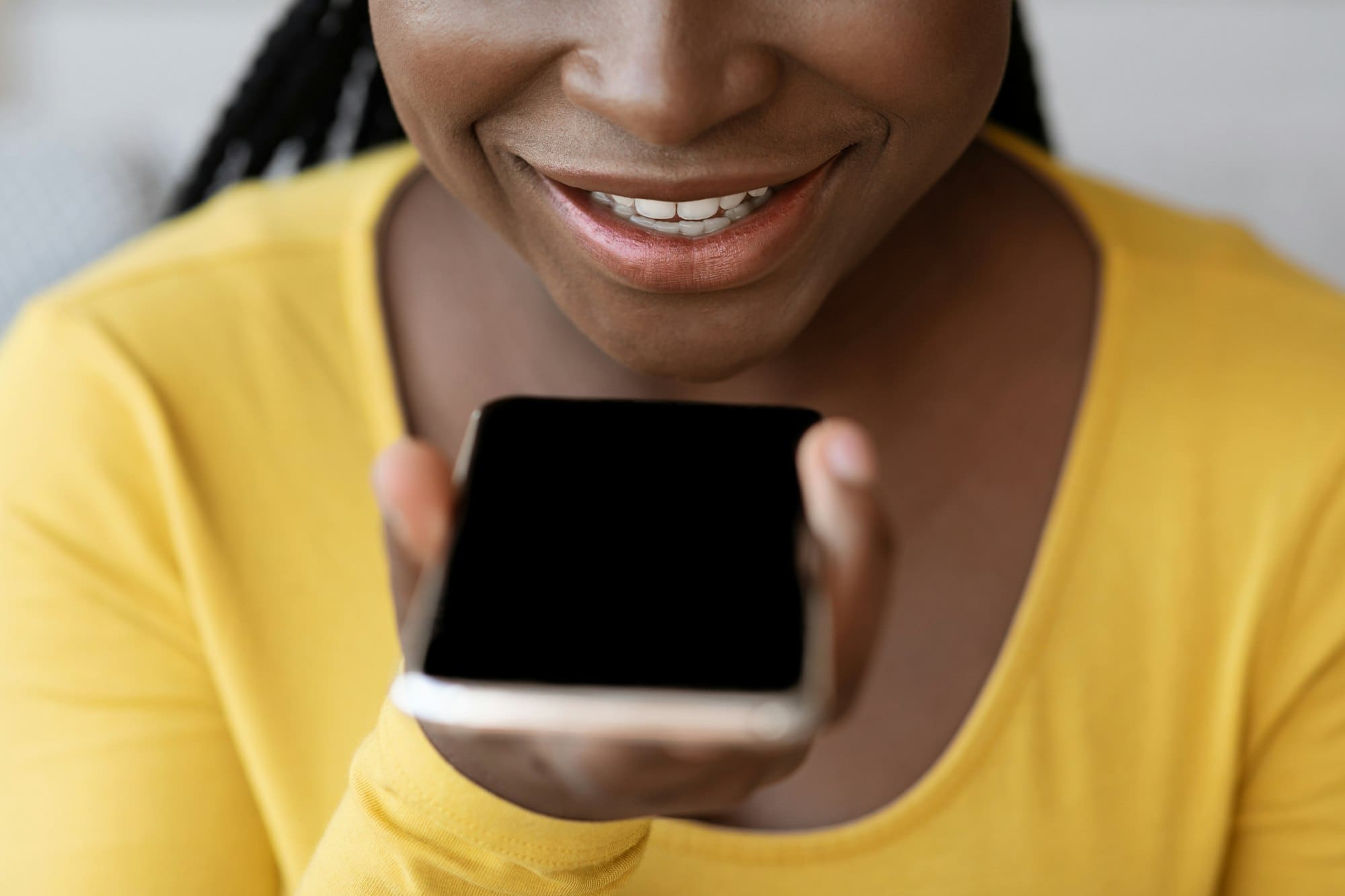 Voice Search Concept. Black woman using personal assistant app on smartphone, closeup