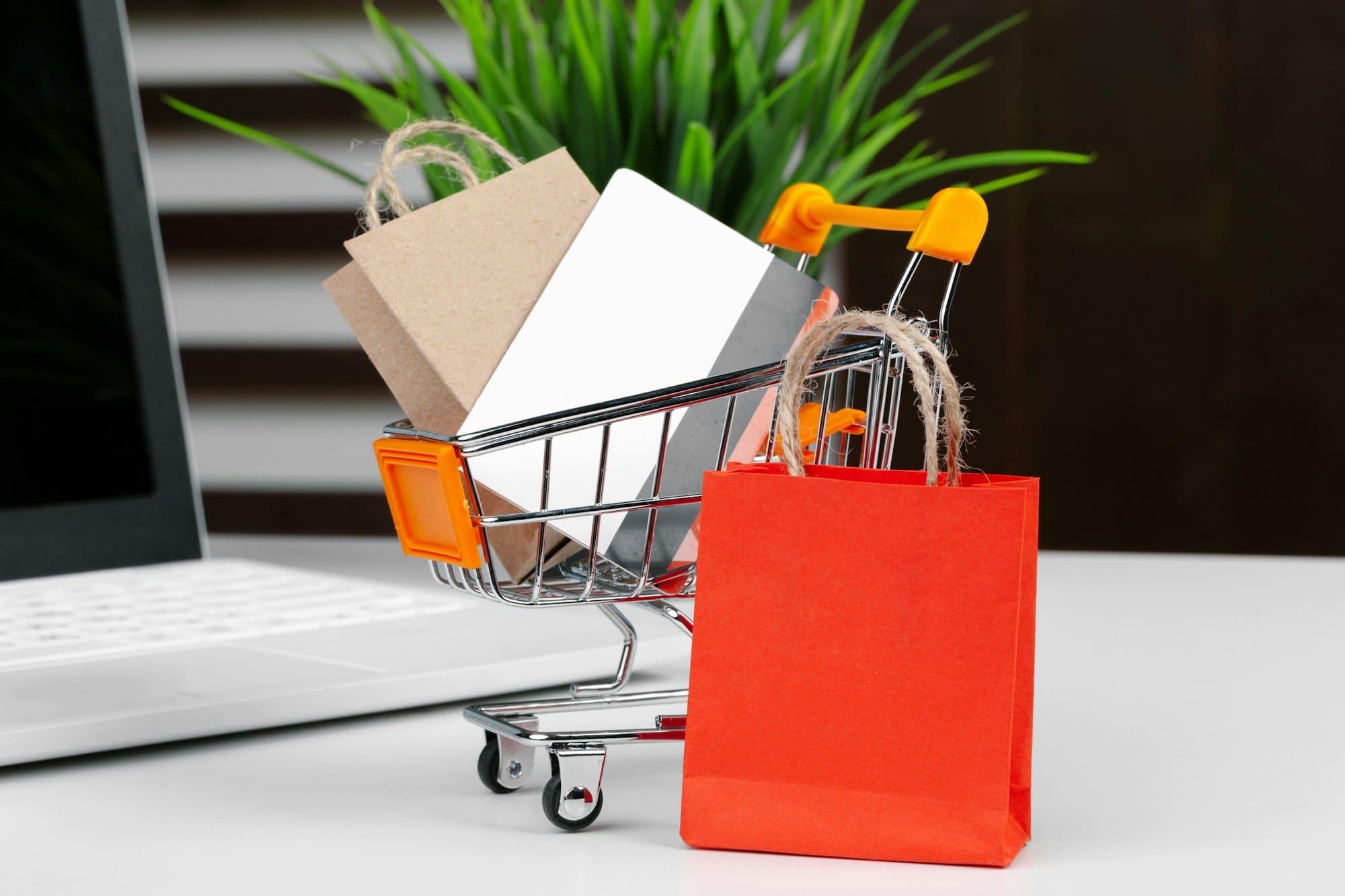 Online shopping concept. Shopping cart, laptop on the desk