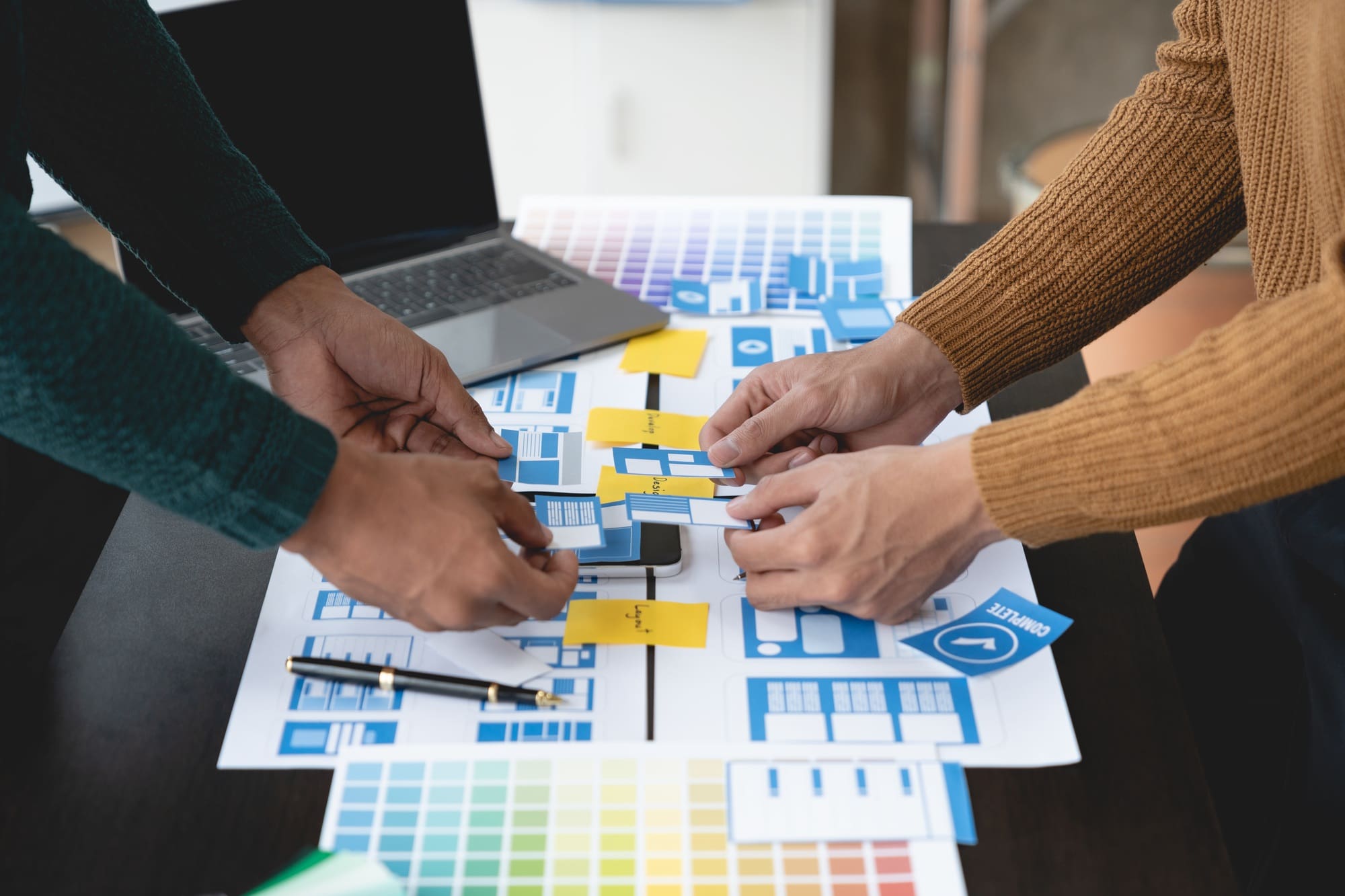 ux developers and ui designers, data researchers brainstorm on tabletop mobile app interface wirefr